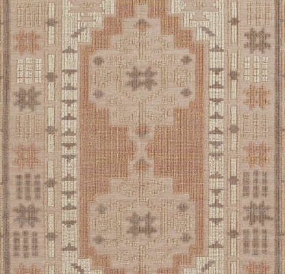 Rectangular oriental rug with two large cream medallions on a rust field, framed by beige and taupe geometric borders.