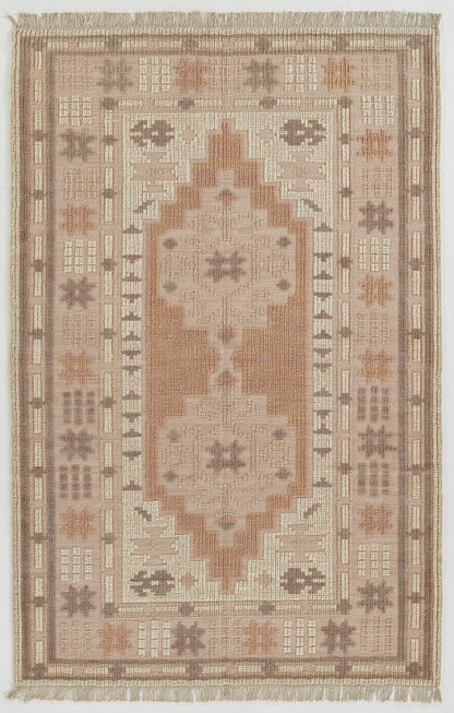 Muted beige-pink oriental rug with central stepped medallion and taupe-cream geometric border, fringed ends.