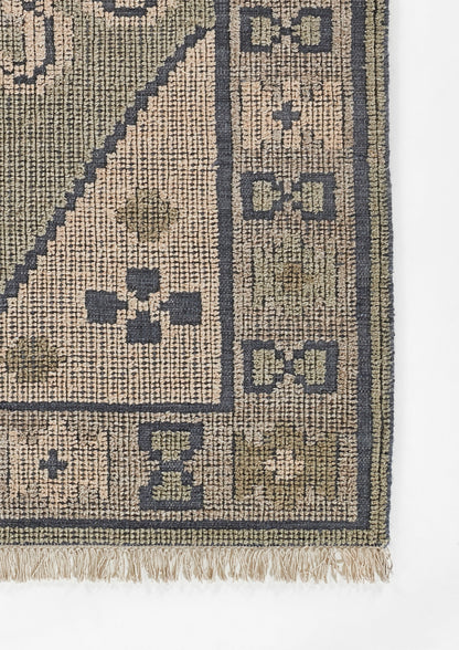 Beige and navy geometric rug corner with lattice border, block motifs, and fringe at the edge.