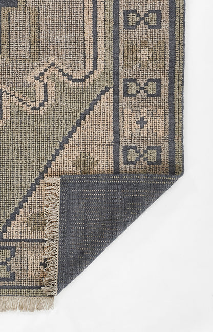 Beige and navy geometric woven runner rug with decorative border, fringed edges, folded to show navy reverse.