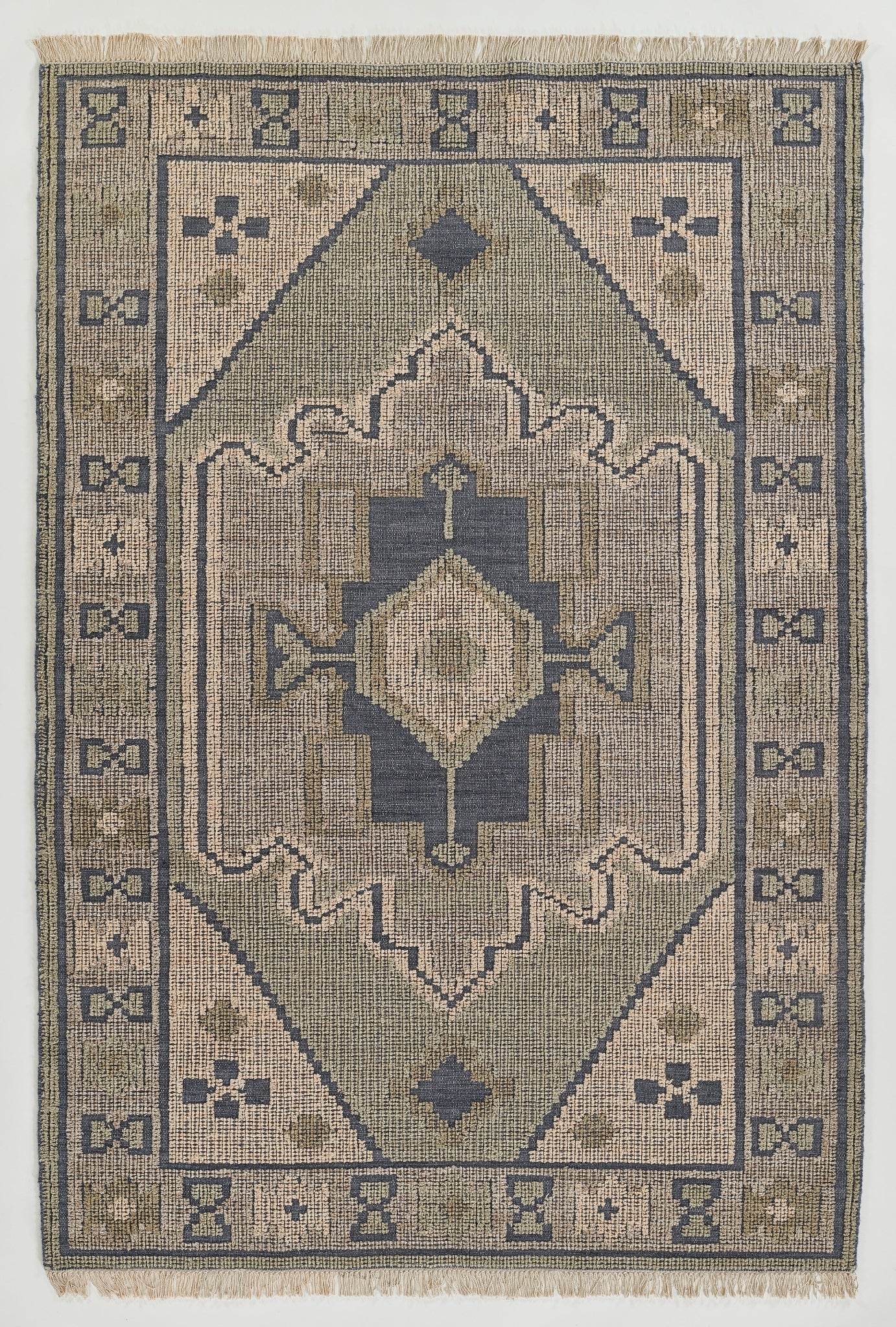 Navy blue and beige rectangular rug with central diamond medallion, geometric border and fringed ends.