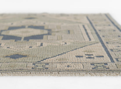 Beige and navy geometric rug, flat-weave with fringe edge, kilim-inspired pattern in a woven wool/cotton blend.