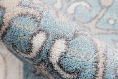 Soft blue ivory shag rug close-up with plush pile and gray-white damask pattern.