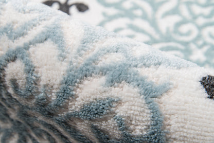 Close-up of a blue and white high-pile plush rug with ornate scroll pattern.