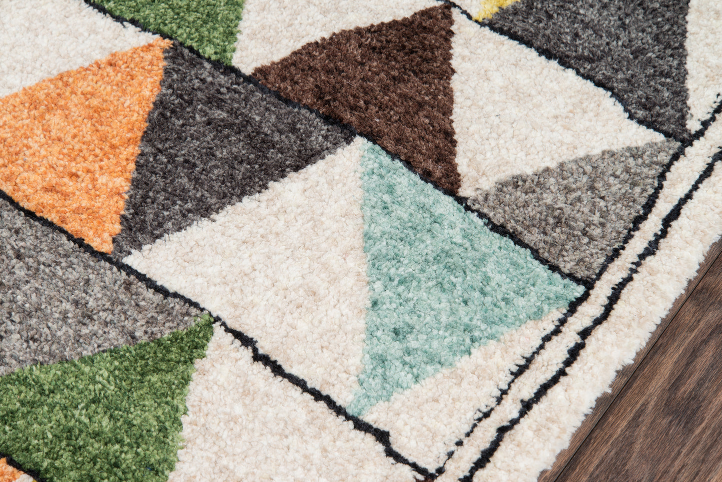 Geometric shag rug with multicolor triangles in cream, teal, orange, green, brown and gray with black outlines on wood floor.