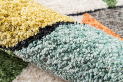 Close-up of a multicolor shag rug with thick plush pile in mustard, teal, cream and a black stripe.