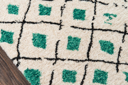 Cream shag rug with black grid lines and emerald green square accents on dark wood flooring.