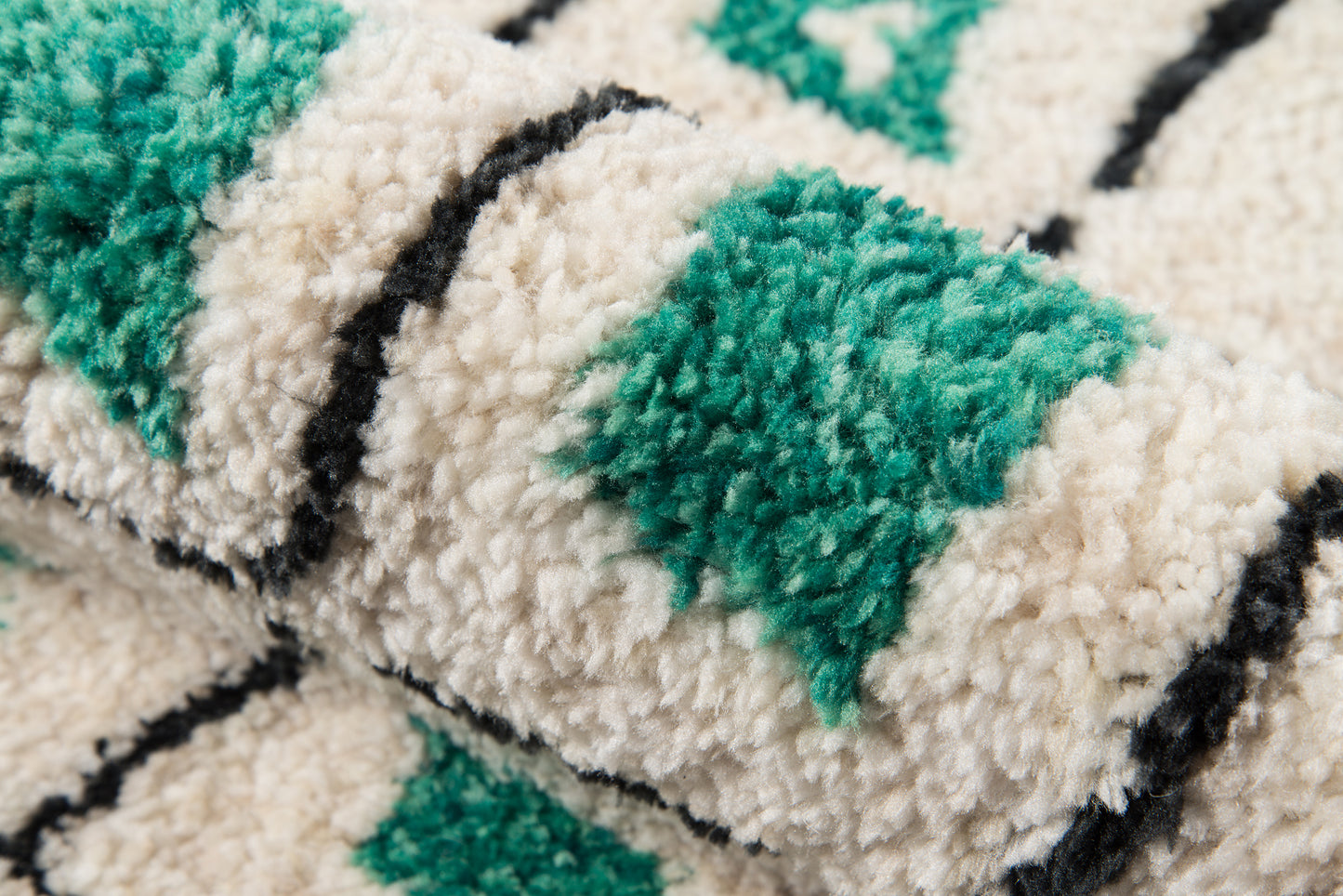 Plush shag rug with emerald green diamond blocks on cream background, outlined by thin black lines.