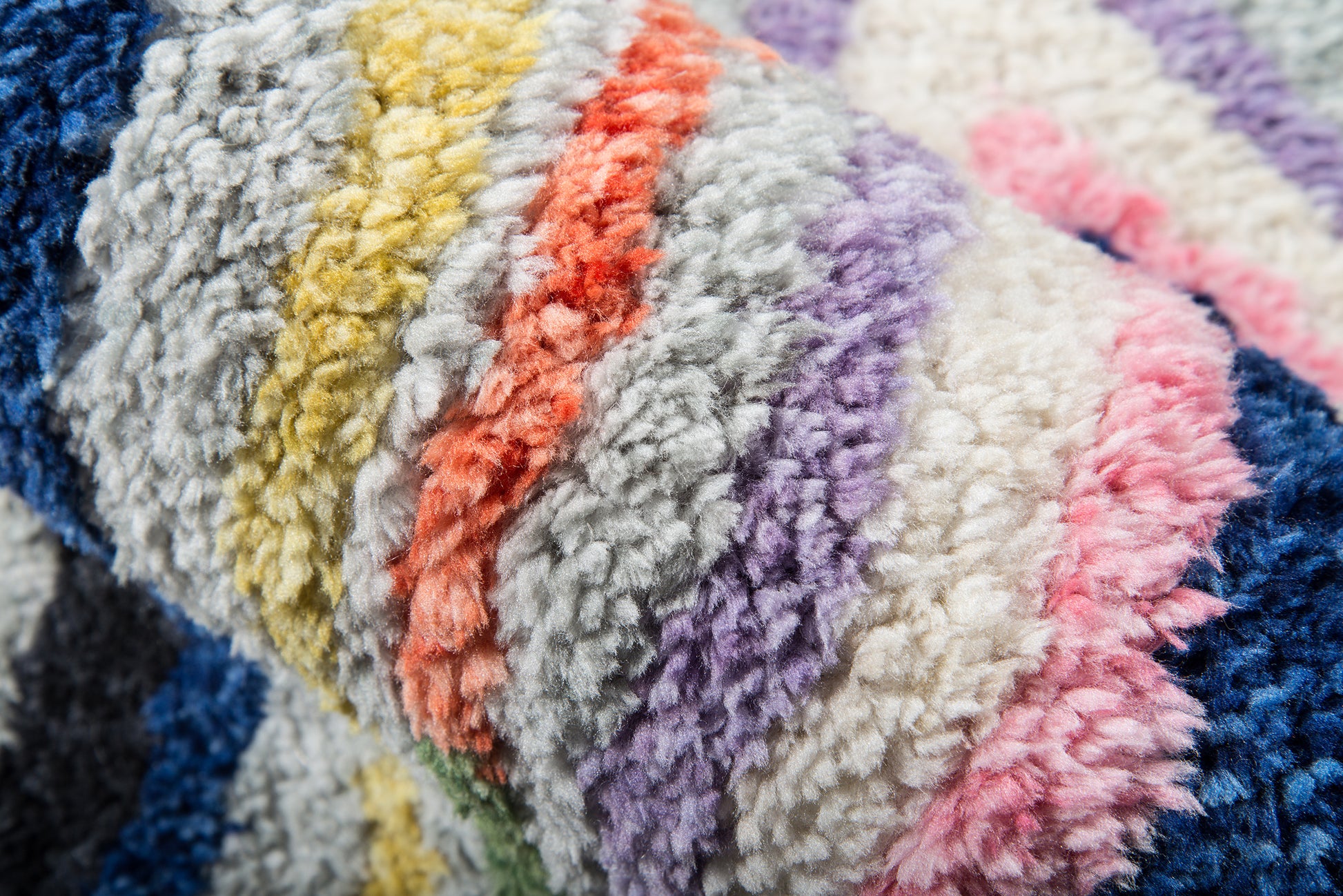 Close-up of plush multicolor shag rug with thick loops in blues, yellows, purples, pinks and whites, 2' x 8' runner.