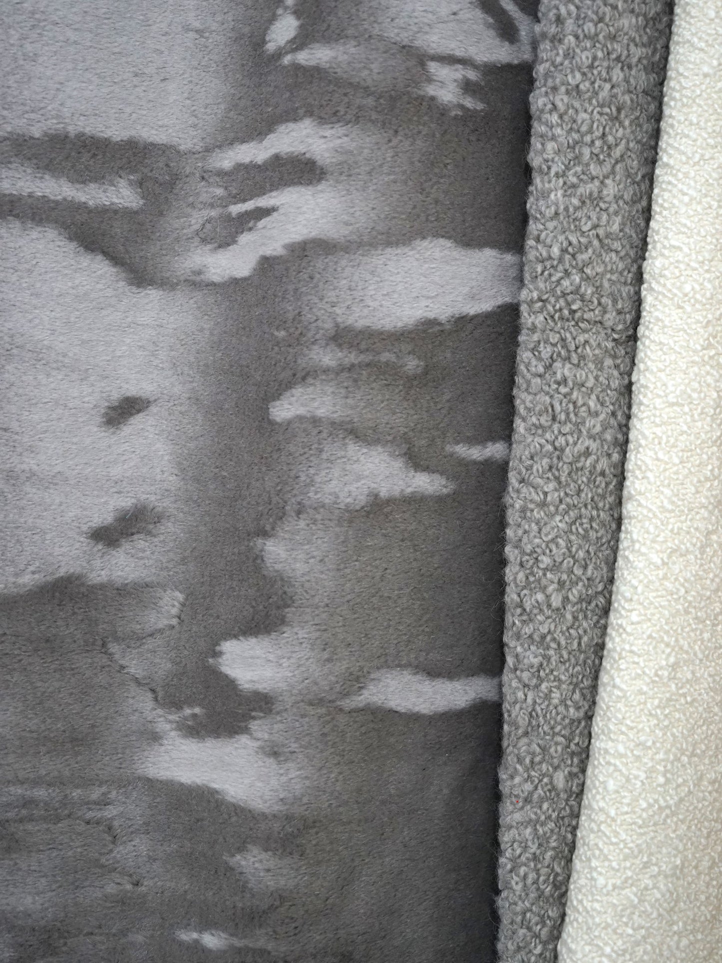 Close-up of ash brown mouton boucle fabric swatch with a multi-textured surface.