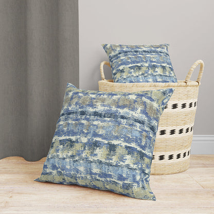 Two blue-gray denim transitional fabric pieces; one on the floor, the other in a woven striped straw basket, coastal rustic decor.