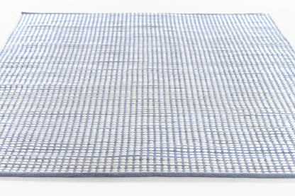 Blue and white woven flat-weave rug with a small checkered grid pattern, rectangular.