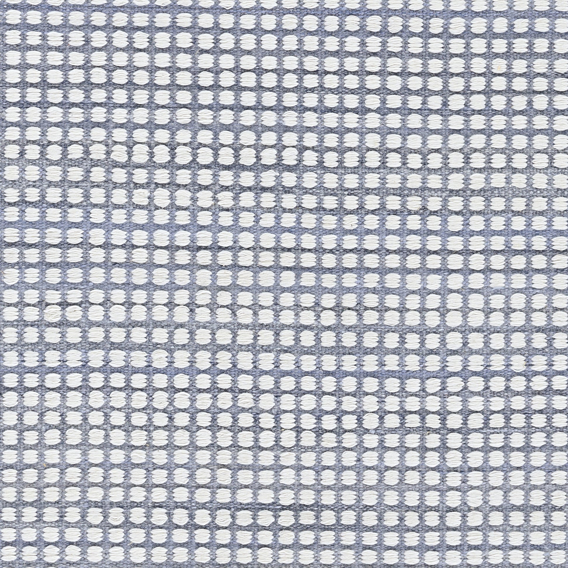 Blue woven rug with white circular dots in a grid pattern; 5' x 8' area rug; textured surface.