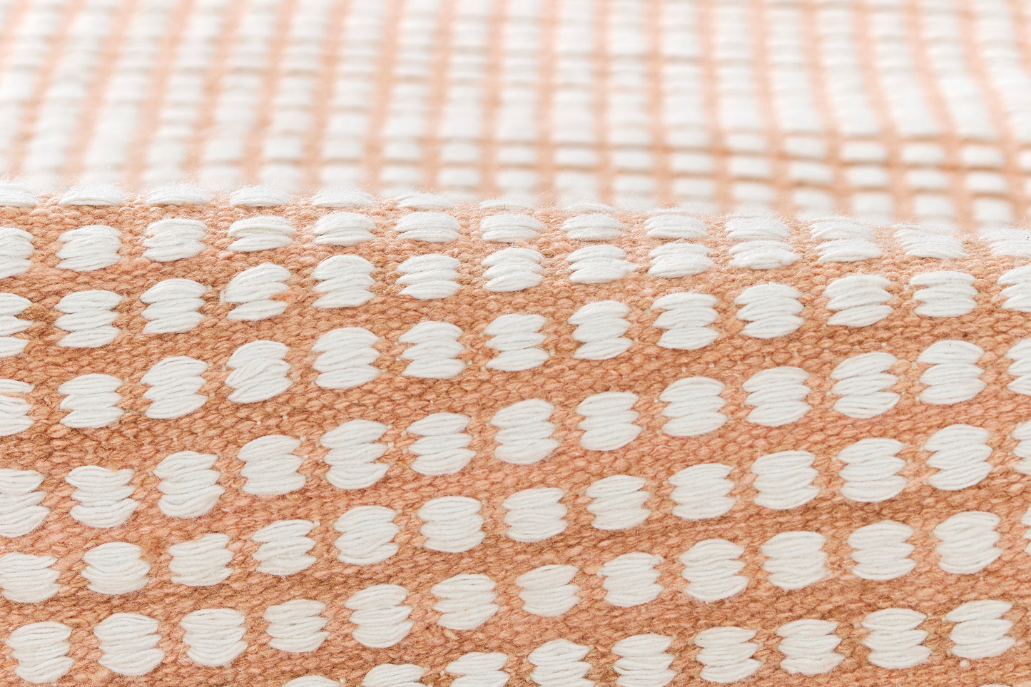 Peach cotton terry rug (5' x 8') with a white raised dot grid pattern; soft area rug for the floor.