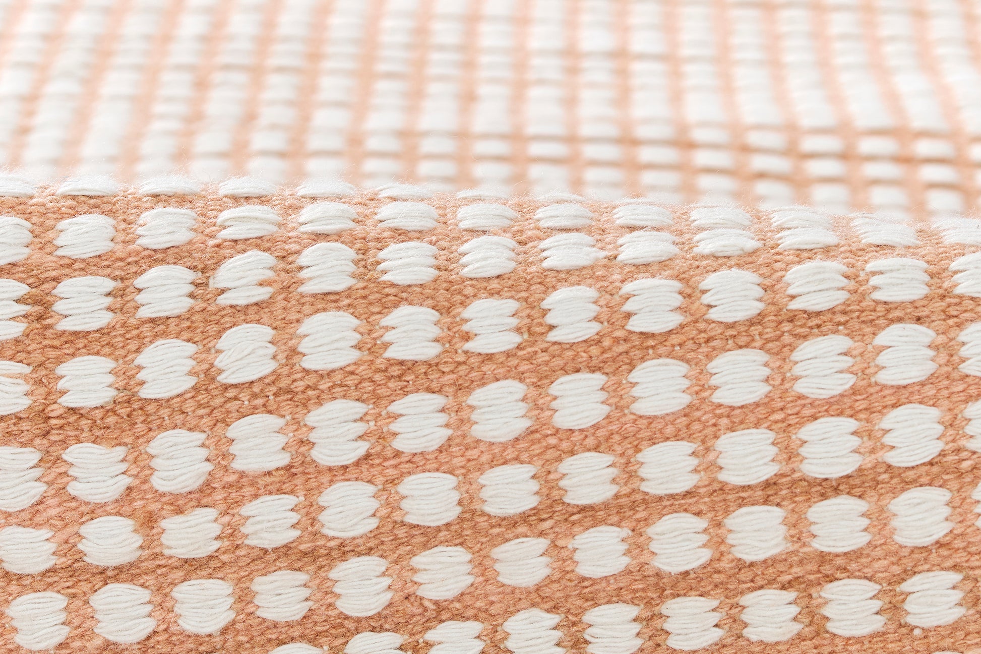 Peach rug with white raised dots in a grid pattern; soft, woven texture, 8' x 10'.