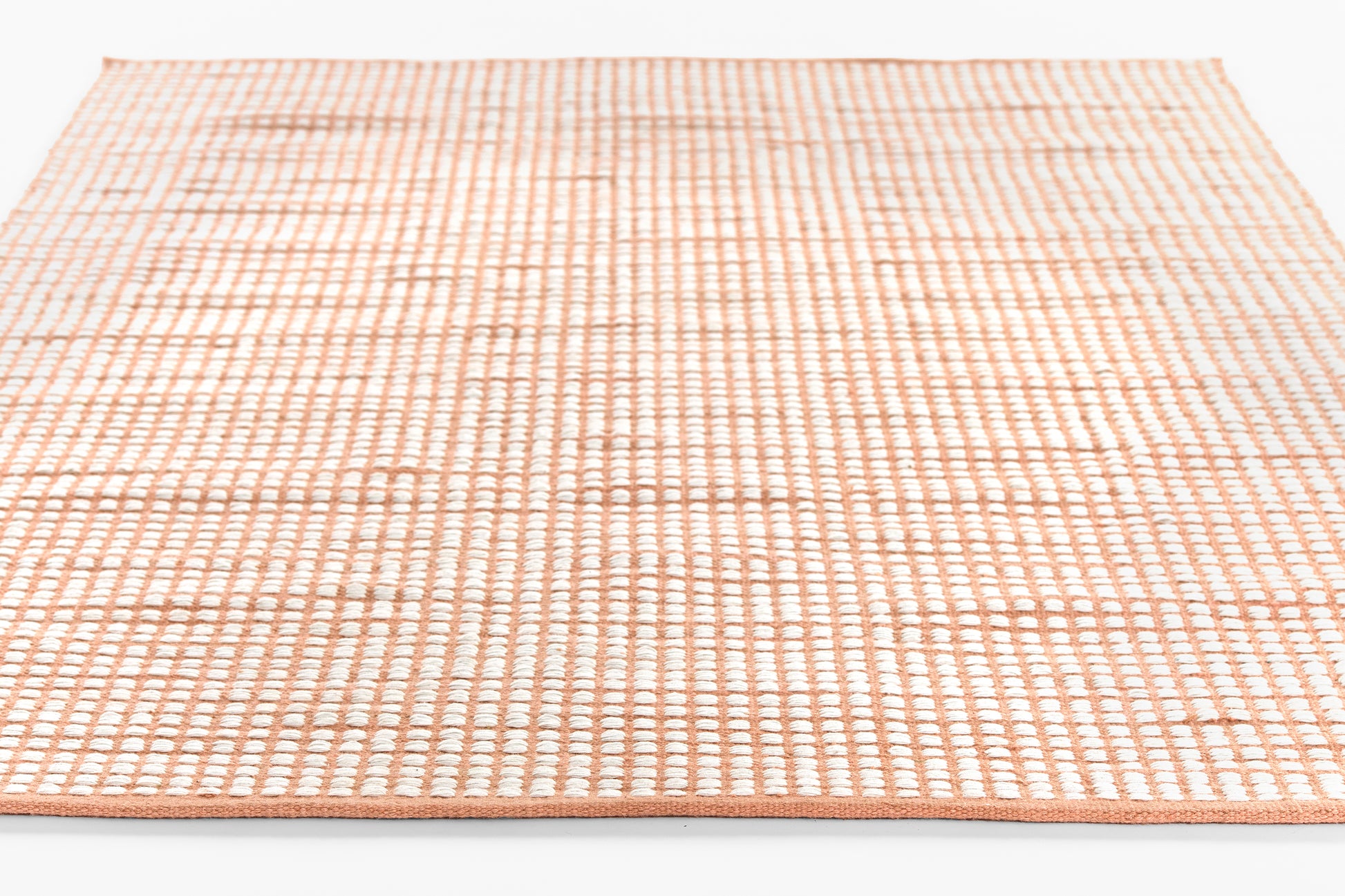 Peach-pink flatwoven rug with white grid pattern, 2' x 3' rectangular area rug.
