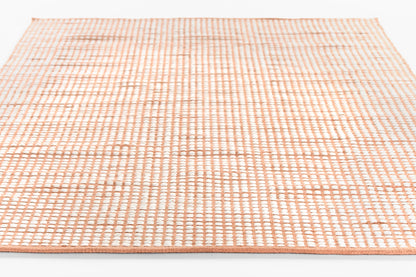 Rectangular rug with peach pink grid pattern on white, woven flat-weave textile, soft and modern.