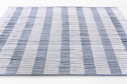 Rectangular woven runner rug with navy, light blue and ivory stripes, modern coastal style.