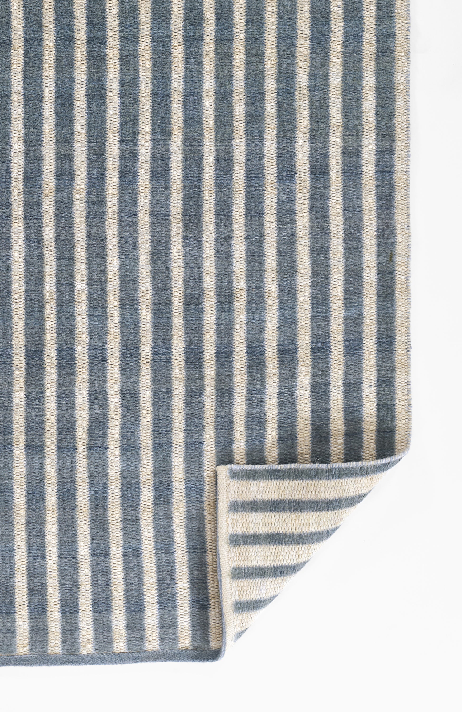 Blue and ivory striped woven runner, rectangular, thick textile with folded corner.