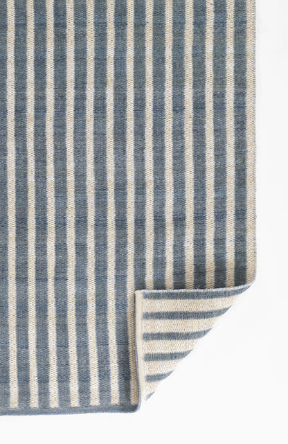 Blue and ivory striped woven runner, rectangular, thick textile with folded corner.