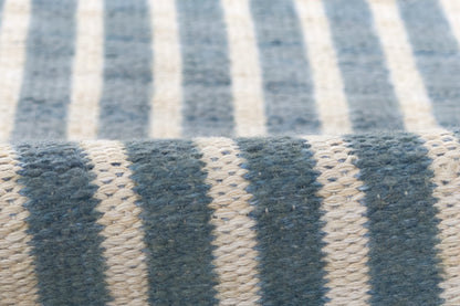 Close-up of blue and cream striped woven rug runner with chunky yarn texture.