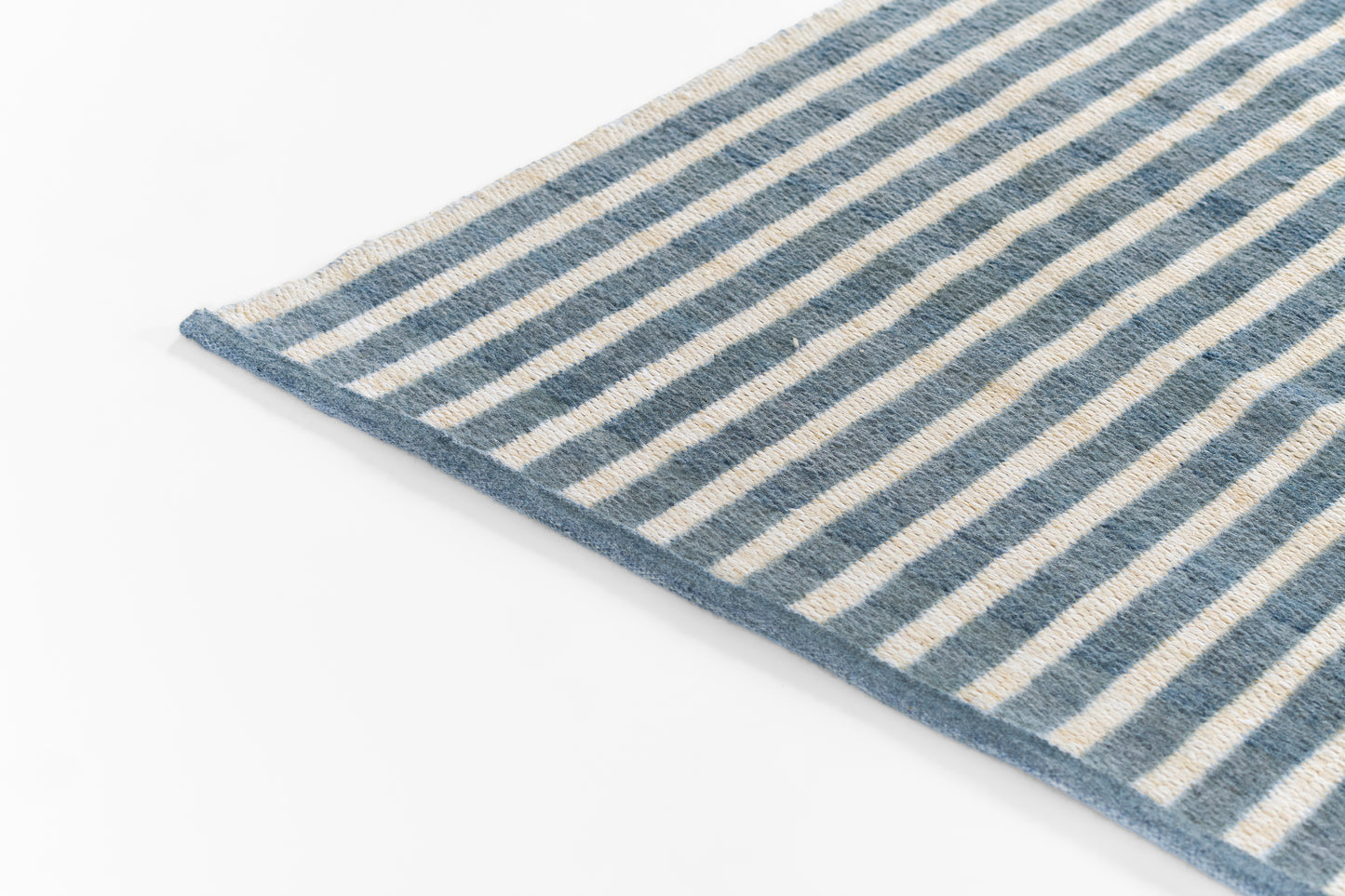 Blue and beige striped woven rug with fringe edge, rectangular, coastal home decor.