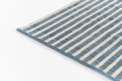 Blue and beige striped woven rug with fringe edge, rectangular, coastal home decor.