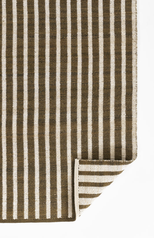 Brown and ivory vertical striped woven rug; natural fiber texture, rectangular, folded corner.