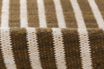 Brown and white striped woven rug with chunky texture and rustic cozy vibe.