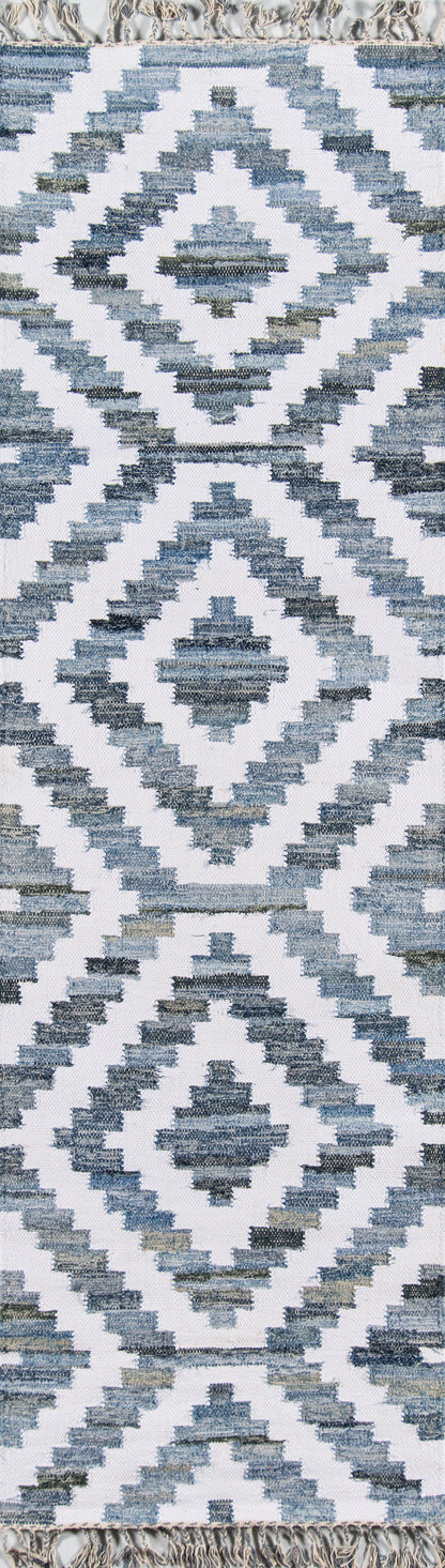 Blue and white geometric kilim-style rug with diamond medallions and fringed edges.