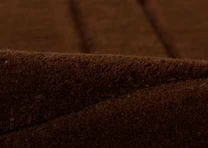 Close-up of chocolate brown rug fibers with a soft, plush texture.