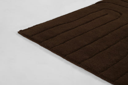 Dark brown plush rug with raised parallel channels and ribbed texture, rectangular 5' x 8' rug.