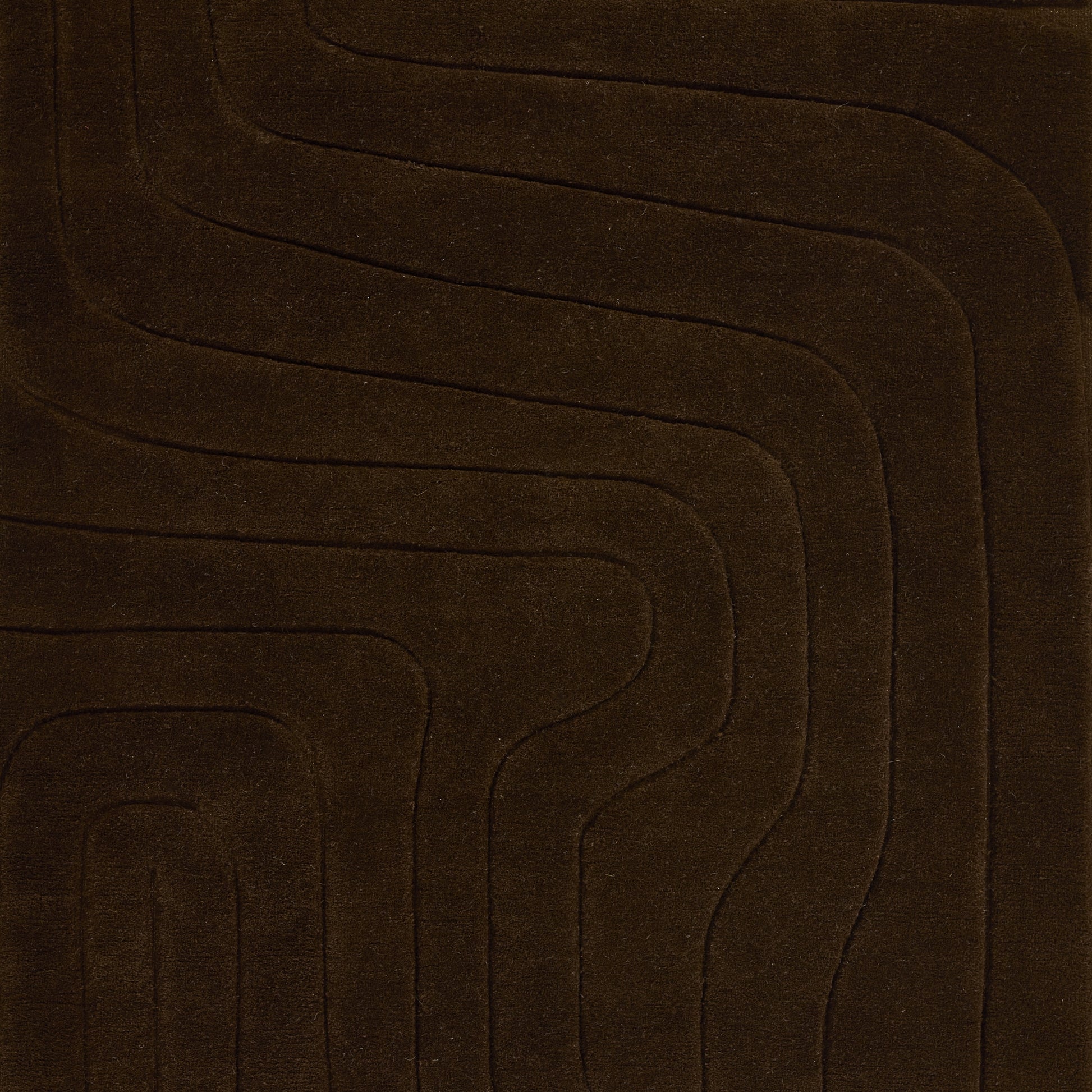Dark brown plush rug featuring a wavy concentric line pattern for a modern geometric floor accent.