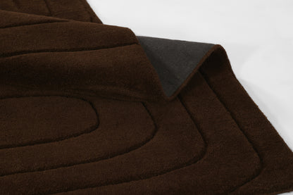 Dark brown suede-like quilted rug with curved stitched panels and folded edge detail, 5' x 8'.