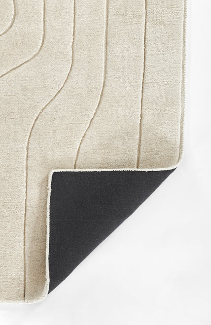 Beige textured rug with abstract raised wave lines; corner flipped to reveal black reverse with white trim.