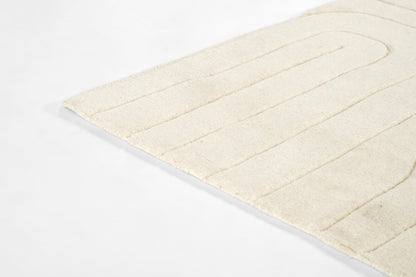 Cream-colored plush bath mat with wide, evenly spaced vertical ribs and soft shag texture.