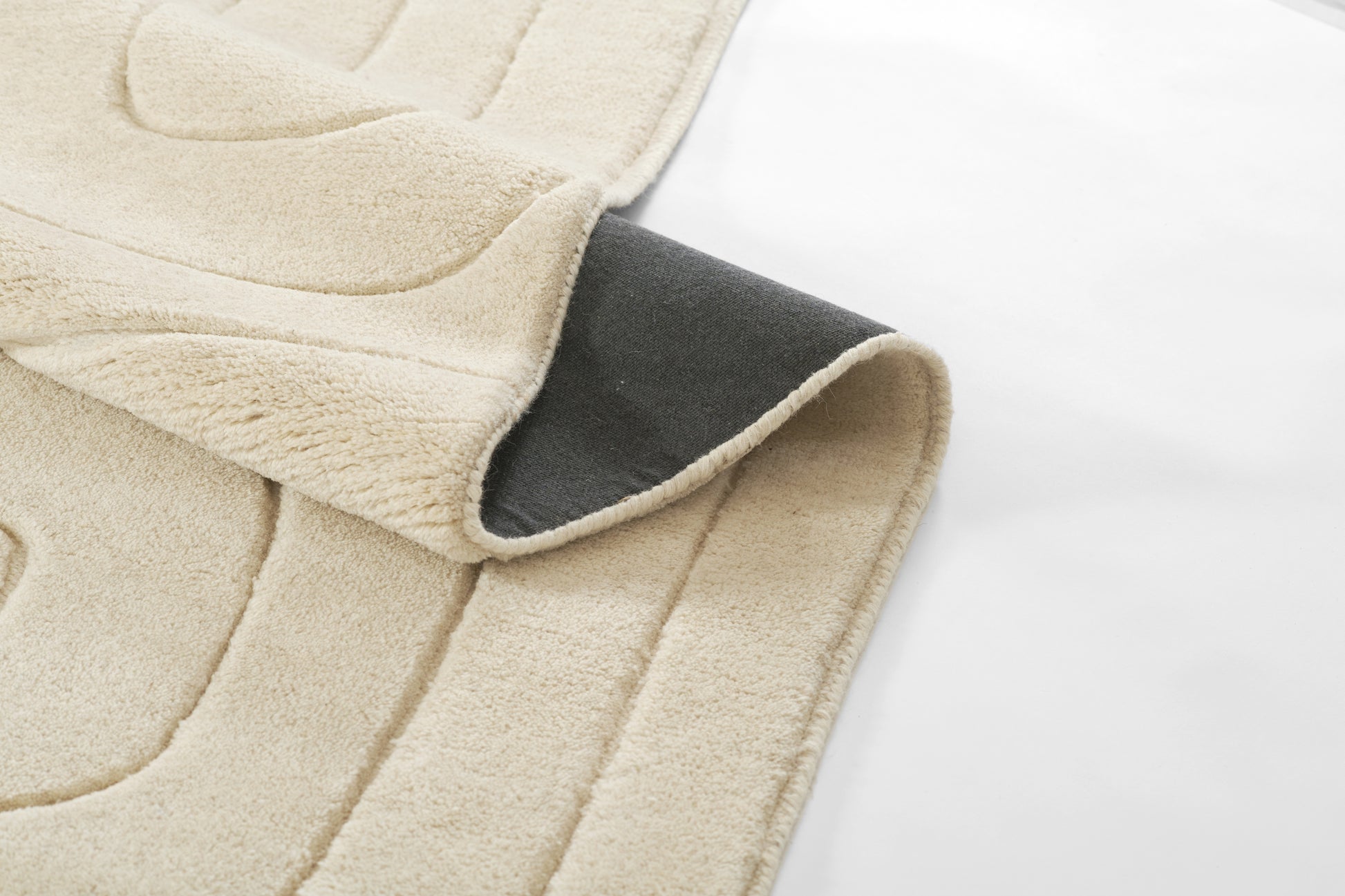 Beige plush throw blanket with gray reverse side, soft fleece texture, cozy for bed or sofa.