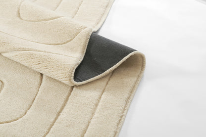 Beige plush throw blanket with gray reverse side, soft fleece texture, cozy for bed or sofa.