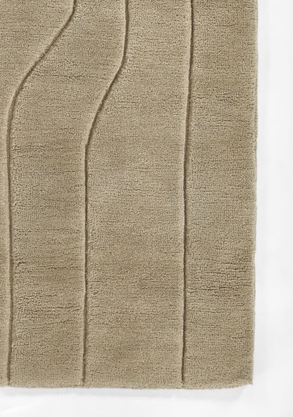Beige plush bath rug with vertical curved channels and soft textured pile.