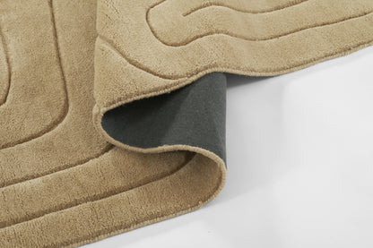 Beige plush throw blanket with curved quilted pattern, dark gray backing visible for cozy decor.