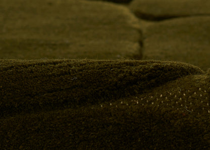 Dark olive-brown suede-like fabric with fuzzy nap and white stitched edge.