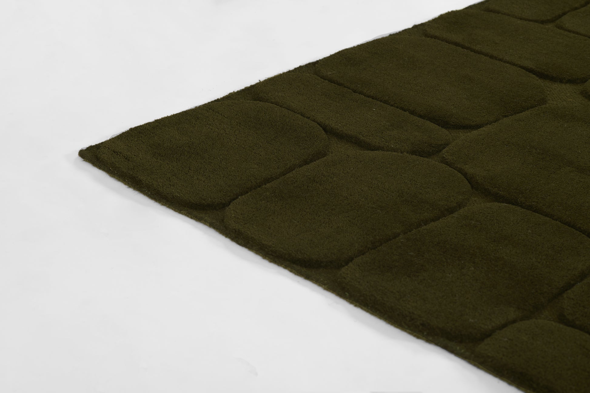 Olive green rectangular quilted rug with square padded sections, plush shag texture, suitable for living room or bathroom.
