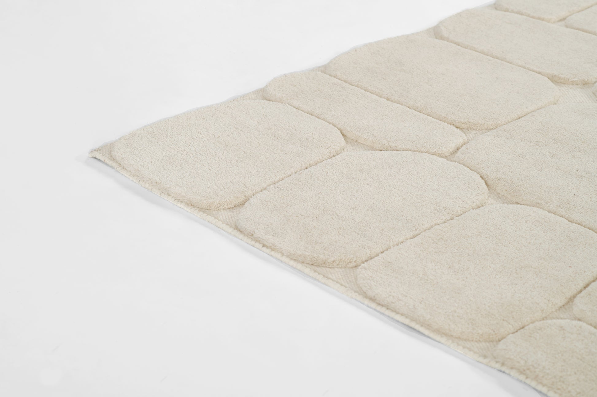 Momeni Canyon 5×8 hand-tufted wool area rug in ivory with high/low carved texture, organic pebble-inspired pattern for living room or bedroom decor, neutral natural wool rug enhancing contemporary and bohemian interiors.