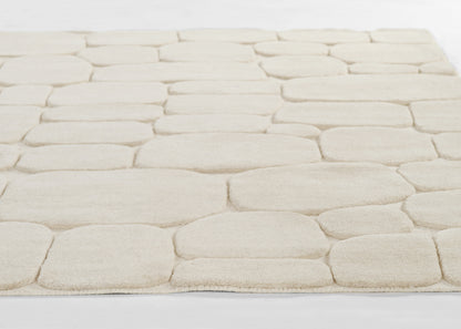 Cream tufted rug with large rounded-square blocks in a stone-like pattern; soft plush pile.