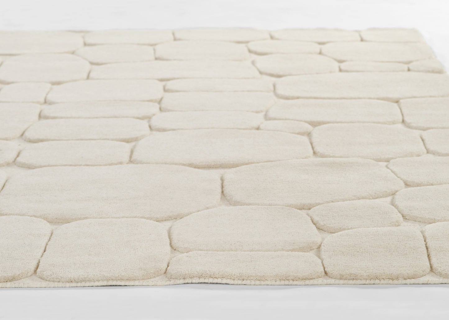 Momeni Canyon 5×8 hand-tufted wool area rug in ivory with high/low carved texture, organic pebble-inspired pattern for living room or bedroom decor, neutral natural wool rug enhancing contemporary and bohemian interiors.
