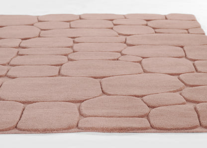 Blush pink shag rug with pebble-like rounded block pattern and plush pile for cozy living spaces.