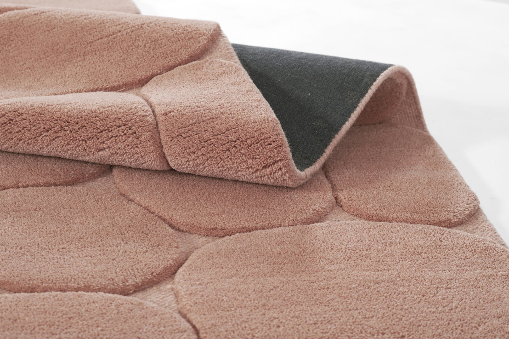 Soft blush pink plush blanket with a dark gray underside, quilted panel texture, cozy throw.