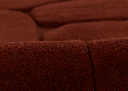 Deep burgundy velvet rug close-up with seam, plush textured pile.