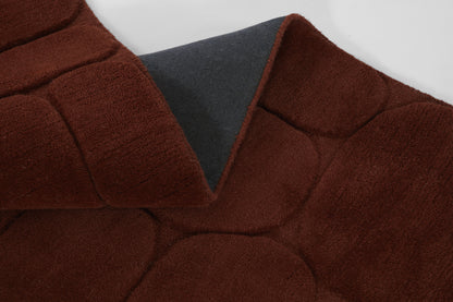 Maroon quilted faux suede coat with dark gray lining at collar, round padded panels for a cozy winter look.