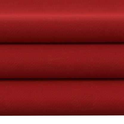 Red textured upholstery fabric rolls with a woven pattern, deep crimson color, stacked layers.